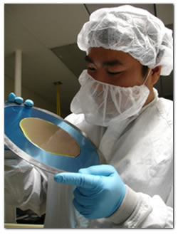 technician inspecting silicon wafer and post fabrication process